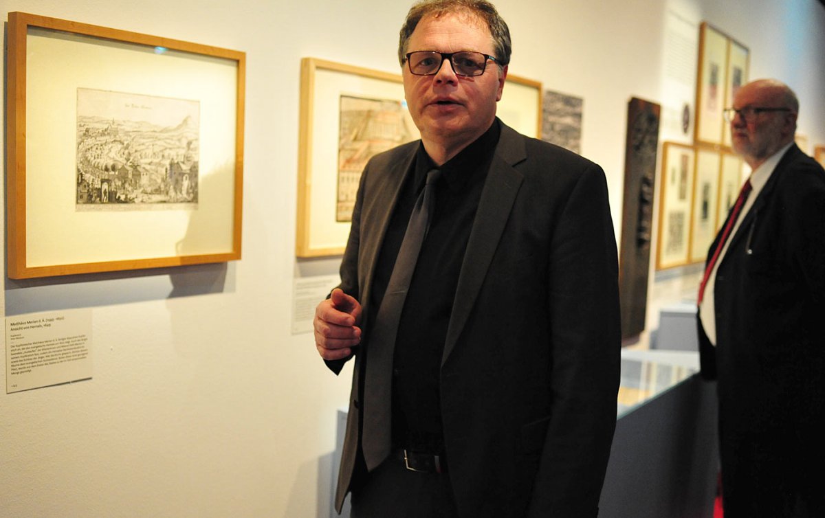 Kirchenhistoriker Rudolf Leeb vor einem Bild, das das „Auslaufen“ der Wiener zu den evangelischen Gottesdiensten außerhalb der Stadtmauern zeigt. Im Hintergrund Ministerialrat Karl Schwarz. Foto: epd/Uschmann