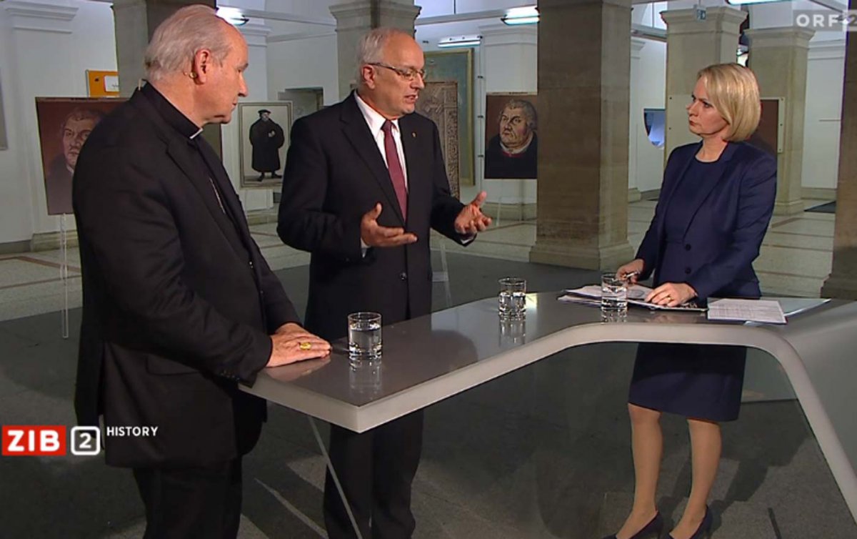 Sprachen sich für eine Ökumene in Verschiedenheit aus: Kardinal Schönborn und Bischof Bünker in der &quot;ZIB 2 History&quot; bei Moderatorin Lou Lorenz-Dittlbacher (v.l.) Foto: ORF/Screenshot