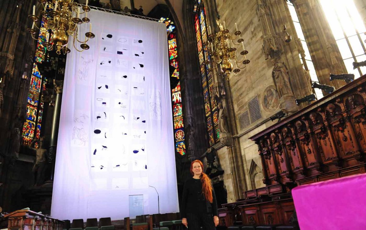   Die aus Kärnten stammende evangelische Künstlerin Lisa Huber vor dem von ihr gestalteten Fastentuch im Wiener Stephansdom. Foto: epd/M. Uschmann