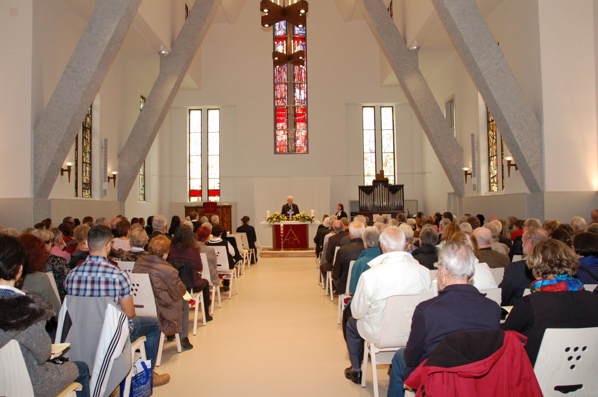 Heller Kirchenraum von innen, voll besetzt