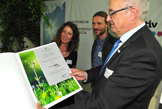Bischof Michael Bünker hält die Klimaaktiv-Urkunde in der Hand, neben ihm stehen Sölkner (Kirchenrätin für Kirchenentwicklung) und Pfarrer Norman Tendis (&quot;Wirtschaft im Dienst des Lebens&quot;) 